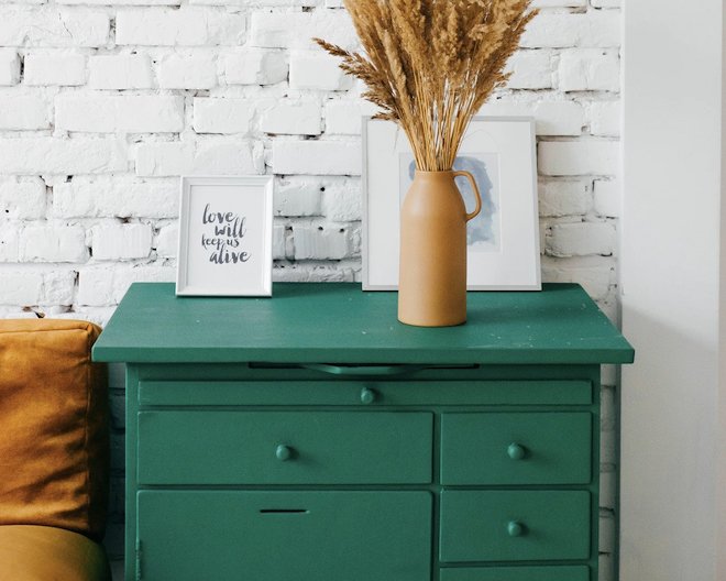 Turquoise drawer with a flower vase and picture frames